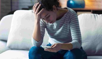 woman sitting on sofa with MFA fatigue