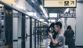 man using phone in chinese train station