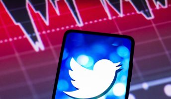 Twitter logo on phone above graph